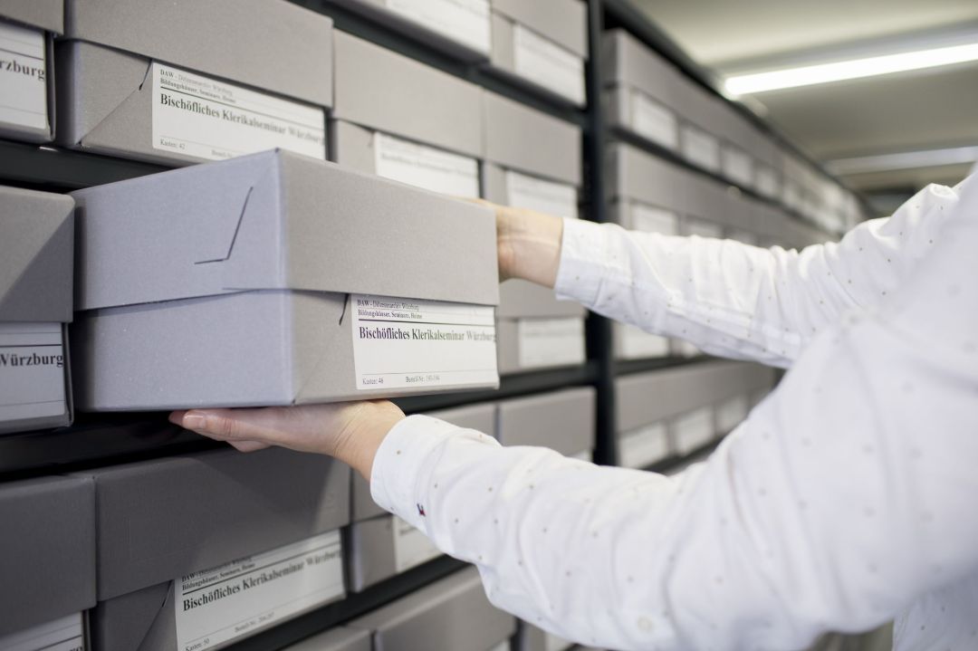 Archivboxen werden aus einem Regal genommen